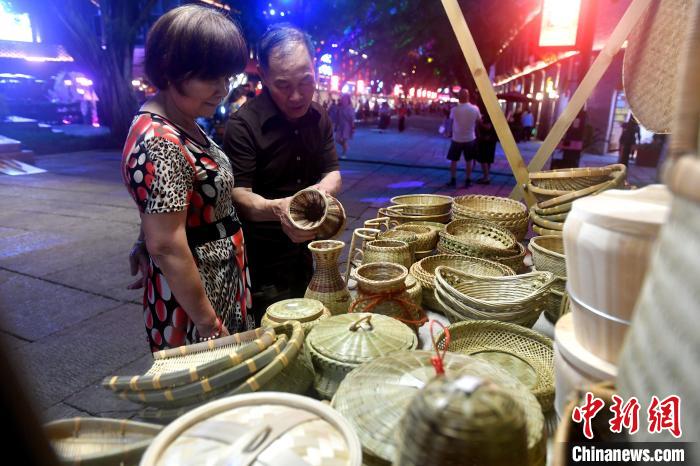 图为竹编文创品吸引参观者。　吕明 摄